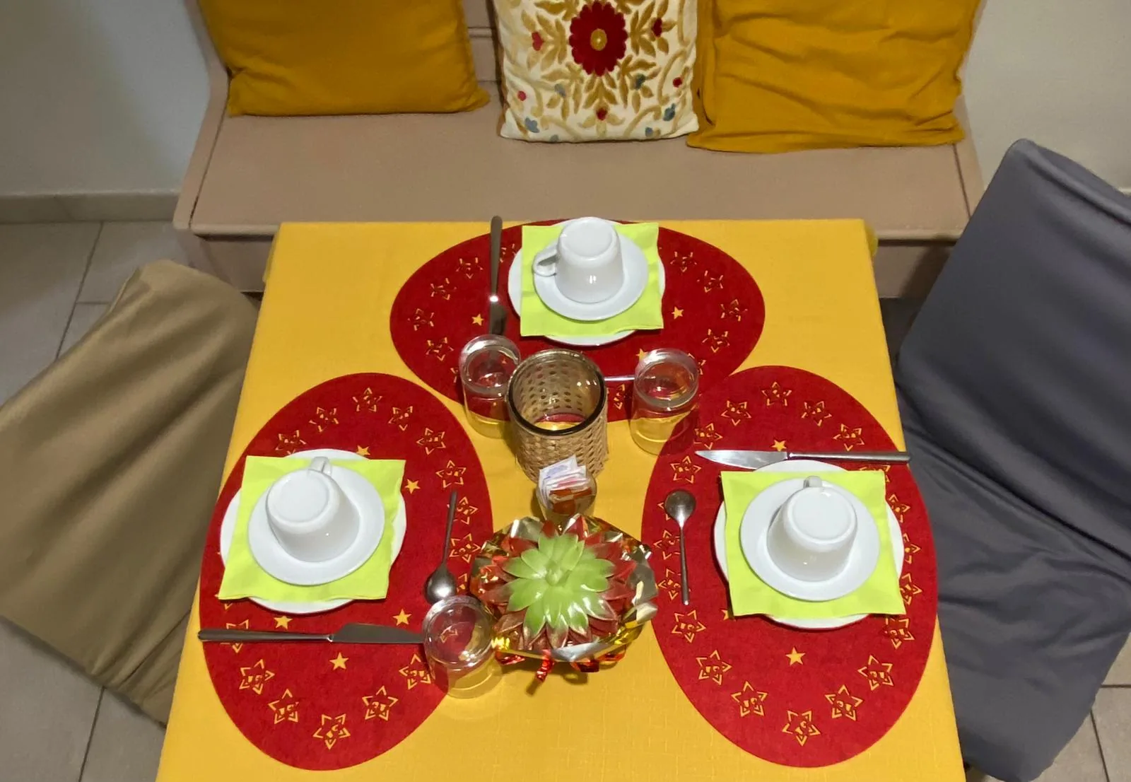 Il tavolo della colazione apparecchiato con tazzine e marmellate